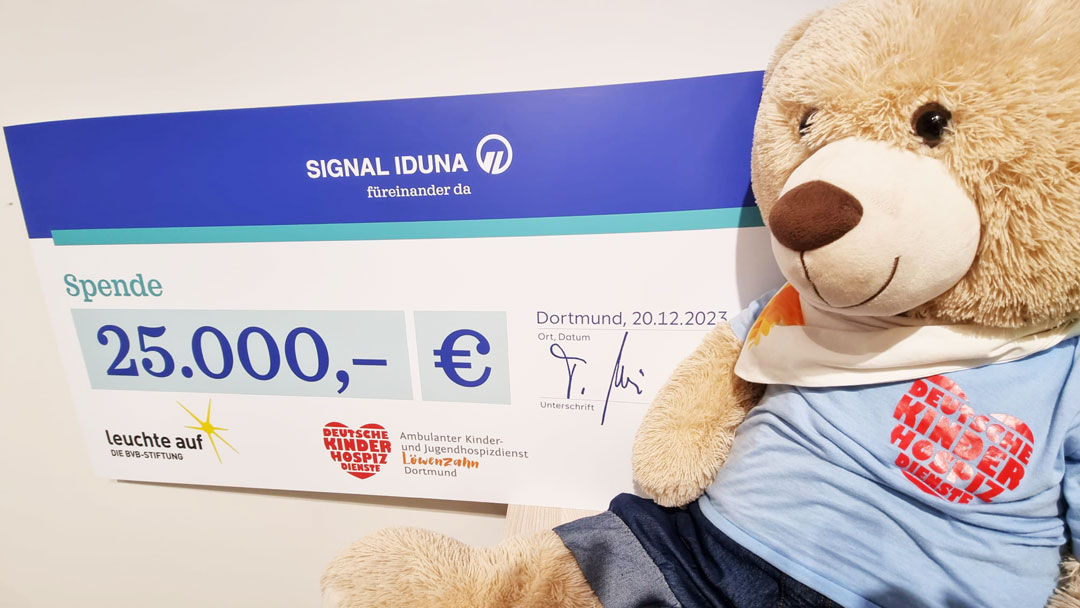 Bärenbotschafter Hope freut sich über den Scheck von Signal Iduna